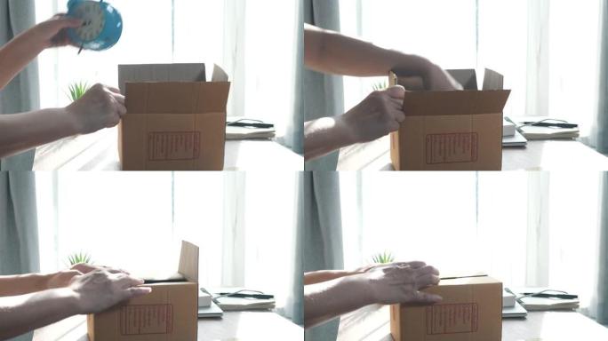 用手将商品包装在眉头包装箱中，准备在家里的窗户附近的地板上带着太阳光发送给客户。
