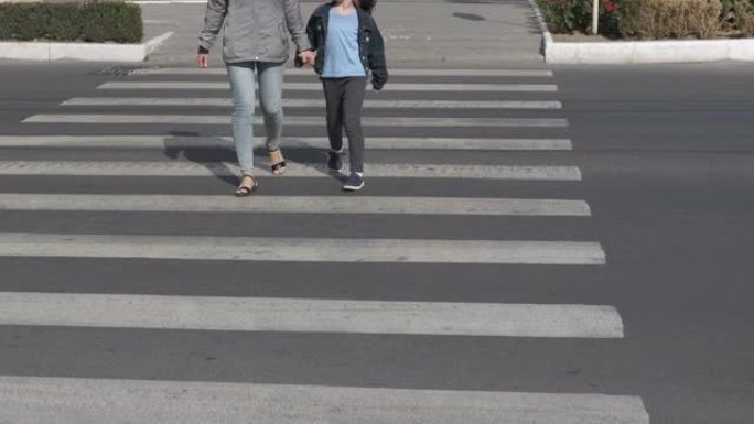 女人在街上牵着孩子的手。