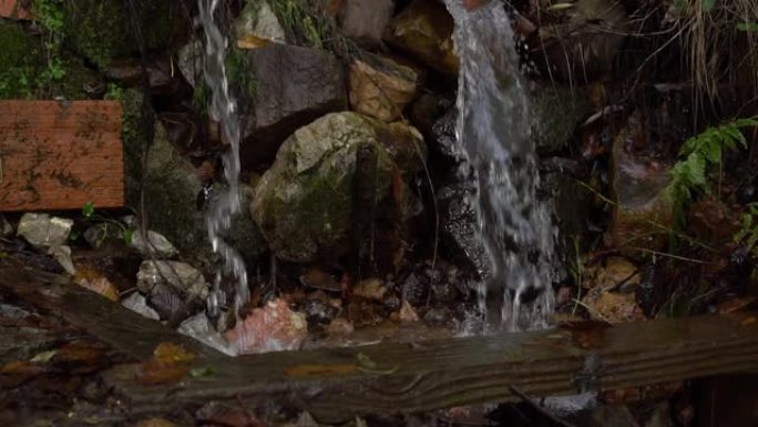 排水水流落在潮湿的石头中并形成飞溅
