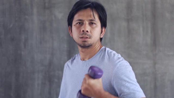 年轻的亚洲男子用哑铃体重锻炼
