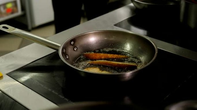 厨师在餐厅的煎锅上用甜酱煎梨的特写镜头