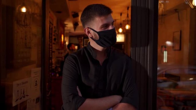 戴着防护口罩的年轻人站在咖啡店