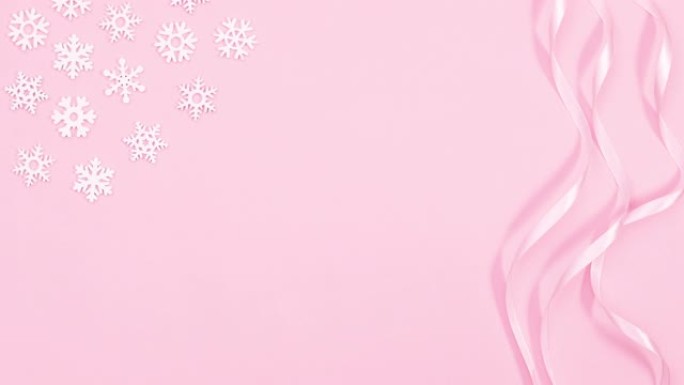 浪漫的圣诞丝带，雪花和银饰以柔和的粉红色主题出现。停止运动