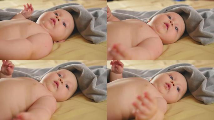 一个胖乎乎的四个月婴儿躺在床上。特写镜头。