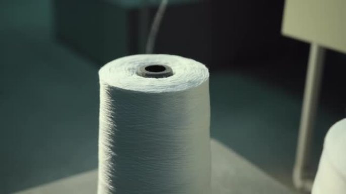 纺织线行业的排行。线轴白线站在机器上。特写