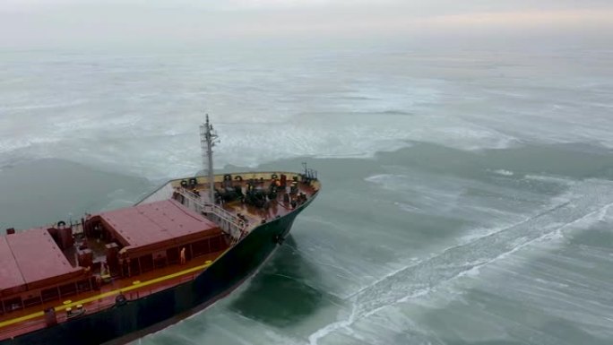空中史诗般的红船在冬季航行通过冰冻的大海。浮冰图形图案。专门用于破冰作业的船只进行了北极北极探险。