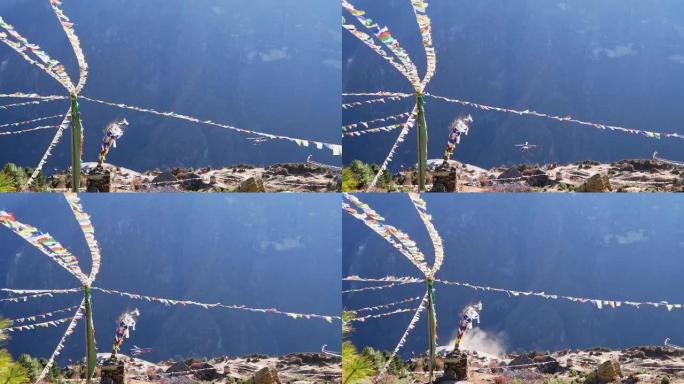 五颜六色的佛教祈祷旗在强风和着陆直升机上飘扬，在尼泊尔夏尔巴人村庄南切巴扎尔上空造成灰尘。