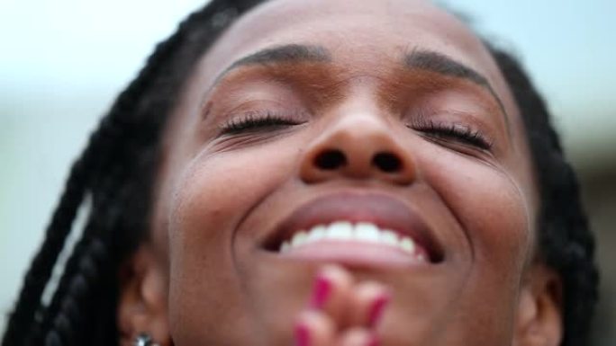 黑人妇女满怀希望地看着天空，非洲人在冥想和沉思中闭上眼睛
