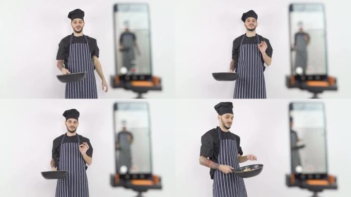 男厨师在网上上课时拿着锅向学生讲解技巧