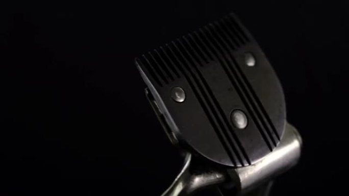 旋转金属复古理发工具旧手动理发推子。在黑色背景上。边缘，安全。4k