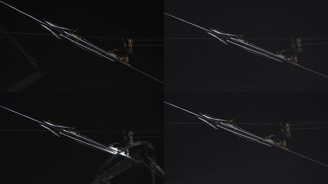 夜间电车受电弓通过的电车电力线的特写镜头。几种选择。
