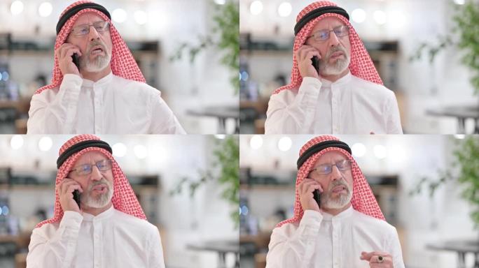 开朗的阿拉伯老商人在智能手机上聊天