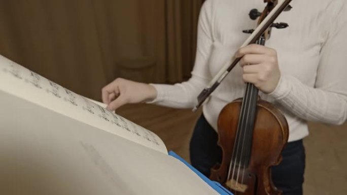 女小提琴家leaf通过乐架上的古典音乐音符
