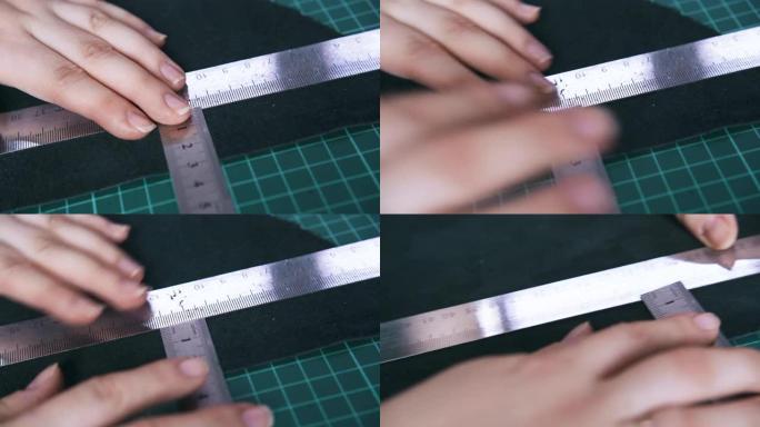 裁缝移动金属尺测量黑色皮革布料
