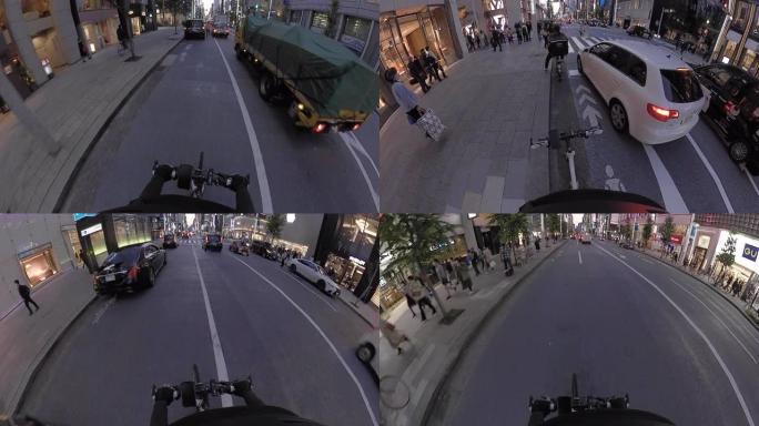 POV在城市里骑自行车。黄昏时骑自行车穿过银座。日本东京。交付服务的概念。动作相机拍摄。
