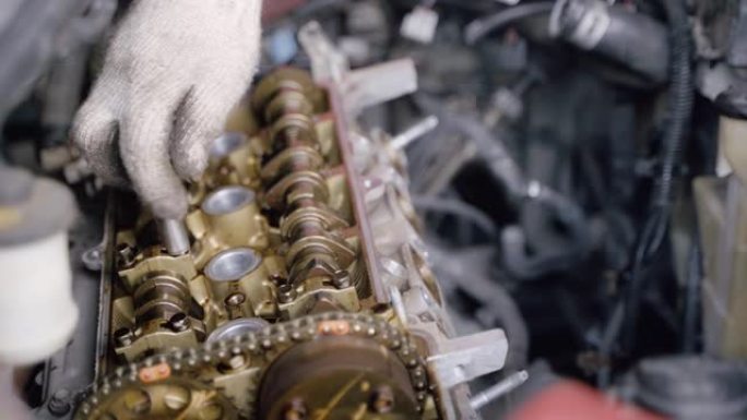 汽车机械师的手配合扳手修理和维护发动机气门气缸体。