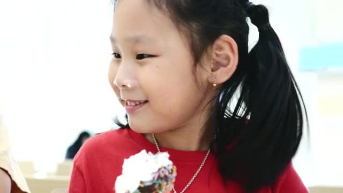 快乐的亚洲儿童在美食广场一起吃冰淇淋蛋卷，生活方式理念。