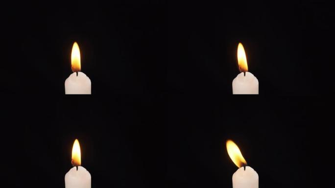 一根蜡烛在黑色背景上点燃。照明。蜡烛火焰