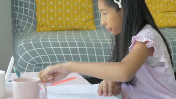 亚洲女孩从家里学习智能手机，家庭教育期间新型冠状病毒肺炎。