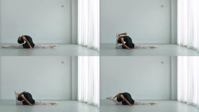 年轻的亚洲芭蕾舞演员在房间里练习前伸展身体