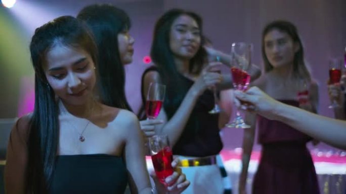 一群年轻的亚洲女性在夜总会跳舞和喝酒。