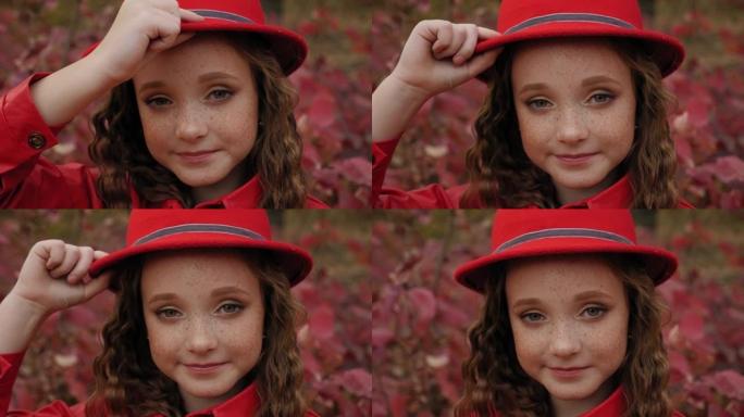 秋天，一个戴着红帽子的雀斑的红发小女孩的肖像。