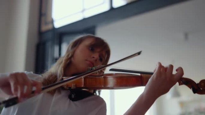 女孩用小提琴练习音乐。小提琴家用弦乐器创作歌曲