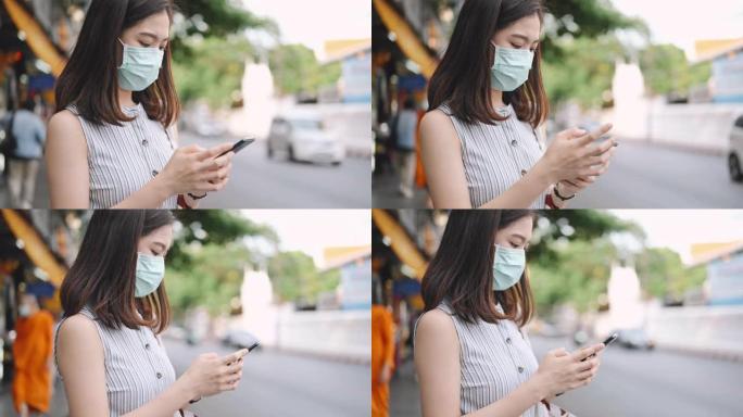 上班后，亚洲年轻女性从城市的moblie app打电话/打车，她的脸上戴着防护口罩。