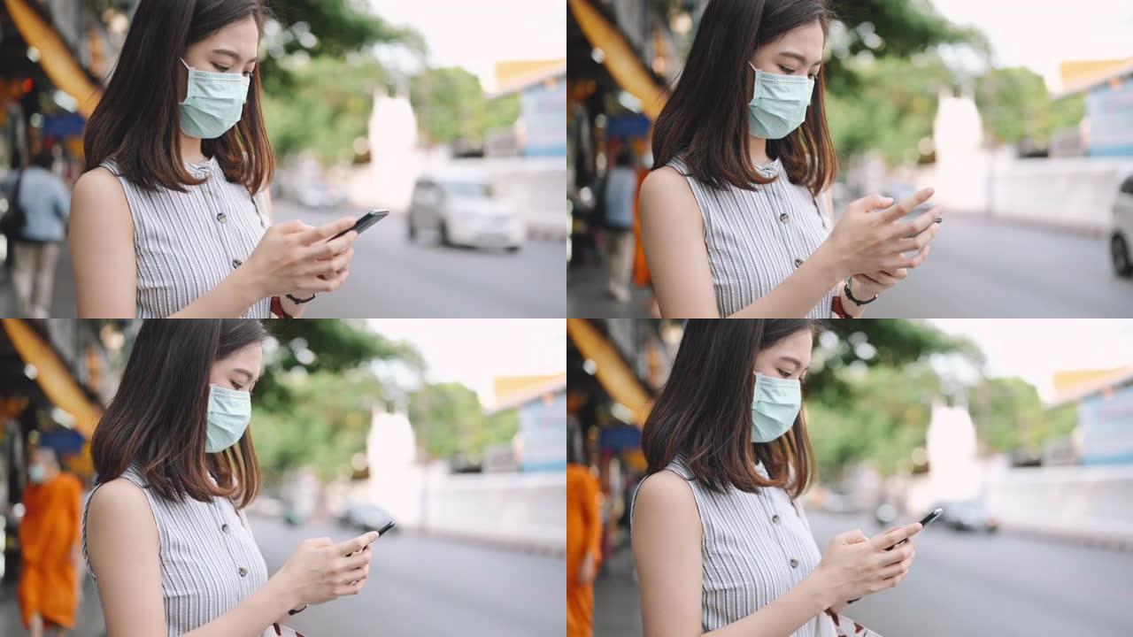 上班后，亚洲年轻女性从城市的moblie app打电话/打车，她的脸上戴着防护口罩。