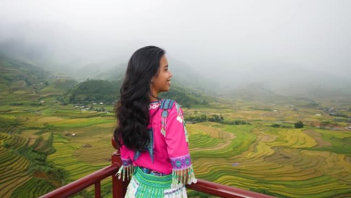 穿着文化服装的亚洲女孩，可以看到令人陶化的水稻梯田景观。