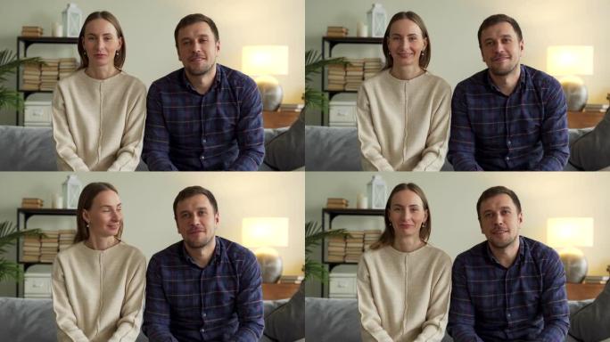网络摄像头查看年轻夫妇视频记录器在家与摄像机流录制视频日志交谈。微笑的夫妇拍摄视频日志