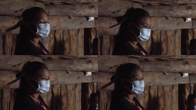 年轻的纳瓦霍女孩手持面具建造纳瓦霍霍根，以防止新型冠状病毒肺炎