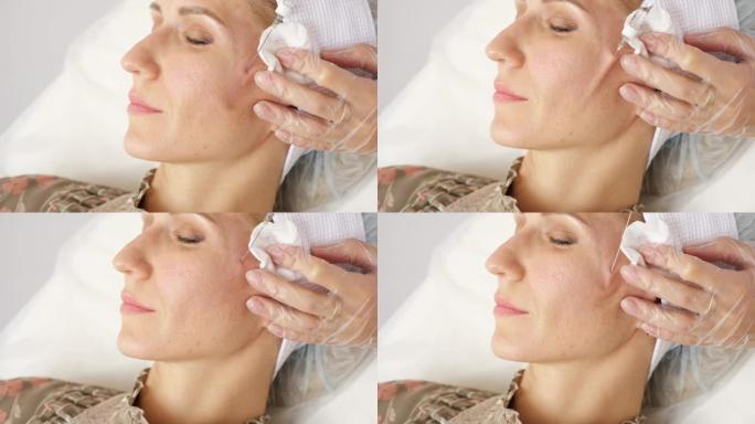 美容师在女人脸上的皮肤下插入一根带有药物的长针