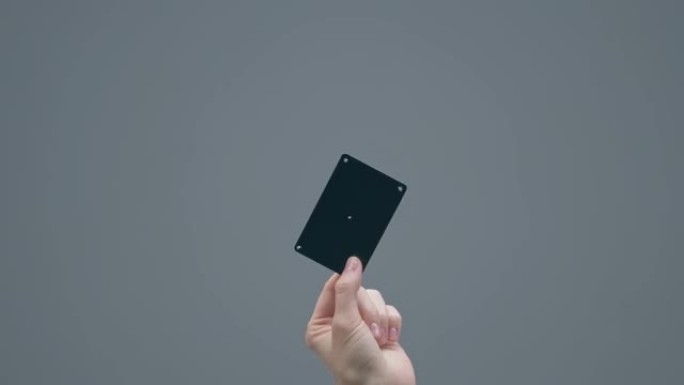 女人的手显示黑色塑料银行卡，带跟踪点，灰色工作室背景，带复制空间