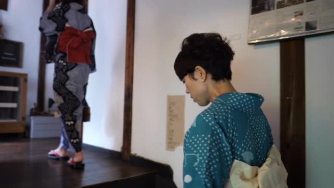 浴衣中的日本妇女在日本房子里走上楼梯