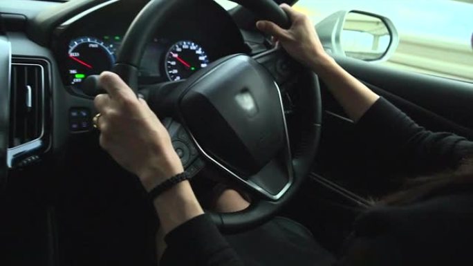 司机POV女人手握方向盘。人手特写的观点。