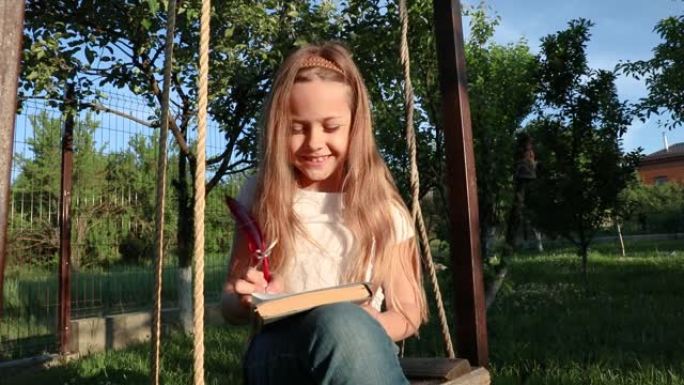 孩子用羽毛笔写一封信。一个小女孩坐在秋千上写下她的梦想。未来的信