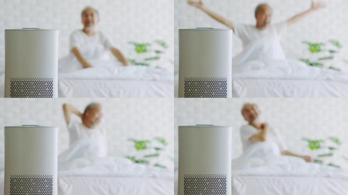 老年人在舒适的白色卧室中使用空气净化器睡觉，用于过滤和清洁灰尘去除家庭中的PM2.5 HEPA，用于