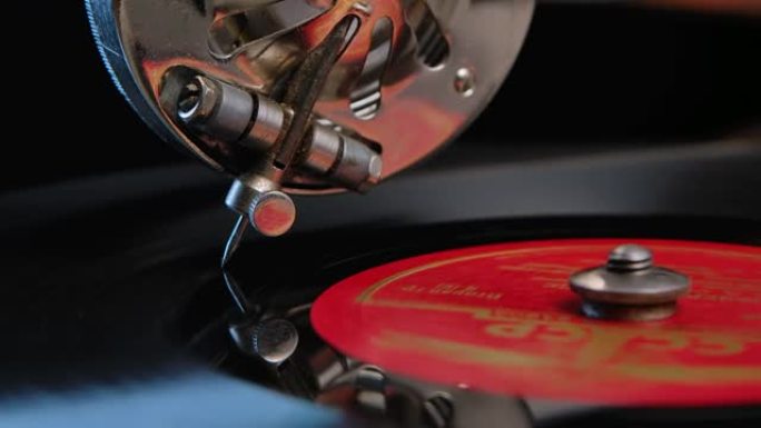 在老式转盘上旋转的黑色乙烯基唱片上平滑滑动的针笔细节视图。演奏留声机的特写镜头。复古概念。慢动作