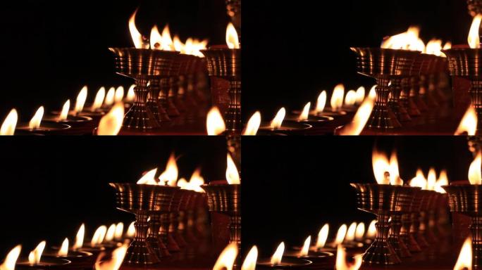 寺庙牛油灯节上的佛坛蜡烛视频。在金属容器中祈祷的油灯和摇曳的火焰，宁静的风景