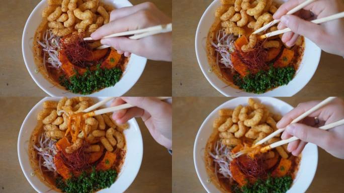 用筷子在白色碗里手工搅拌纯素食日本拉面的俯视图。植物性东方美食的顶级美食博客食谱