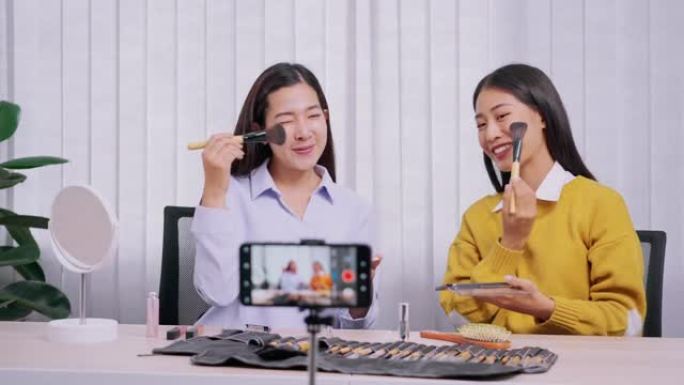 年轻的亚洲女性为自己的博客制作化妆品视频展示产品，并通过互联网在家美容博客概念向社交网络直播视频