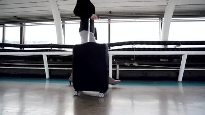 商务女性旅行者在机场步行拉手推车