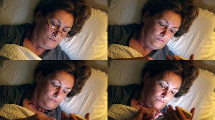 躺在床上的老妇人看着盯着蓝光屏幕的手机设备