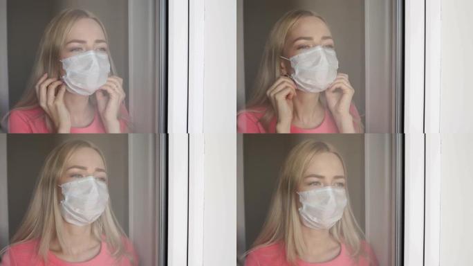 家庭检疫。白人妇女戴着医用口罩站在窗前，向外看