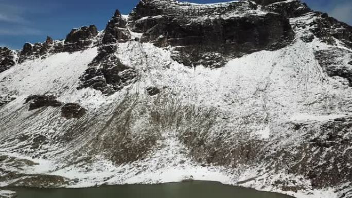 一架无人机拍摄了奥地利Feldseekopf附近的一个湖泊。湖面被积雪包围，部分覆盖了阿尔卑斯山的石