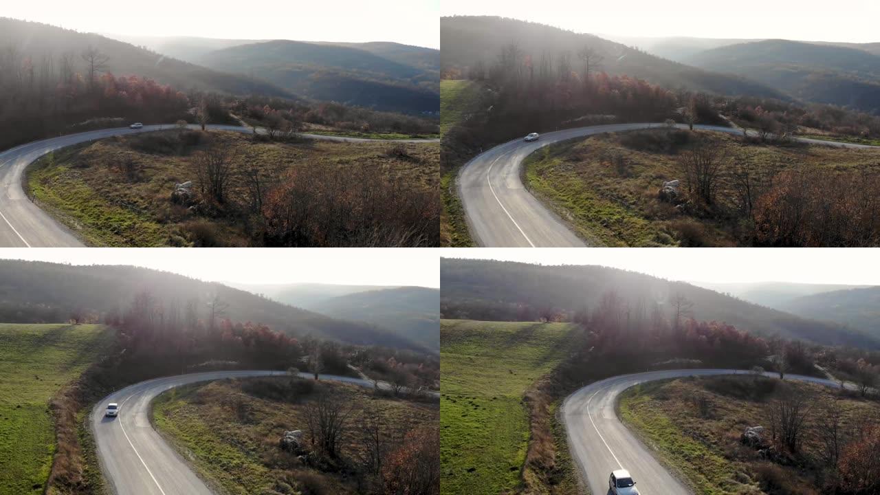 从山上飞来的无人机的航拍-越过山的道路，山的岩石景观