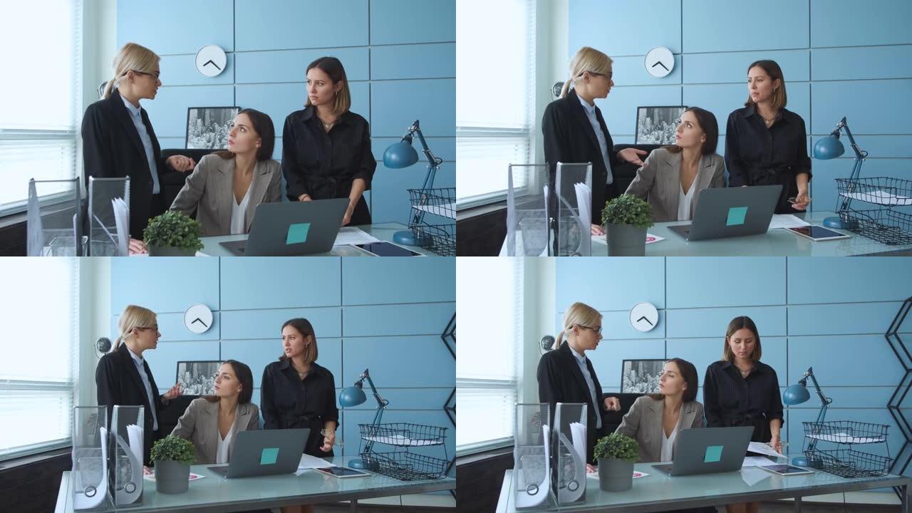 年轻的女商人在现代办公室的休息区与不同的同事交谈