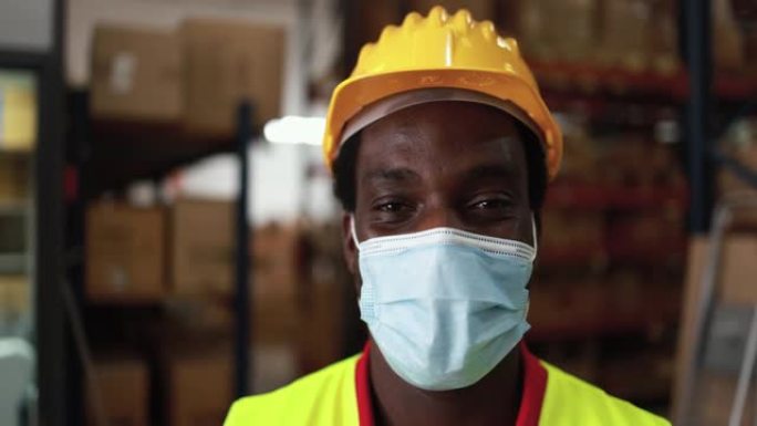 非洲工人男子在送货箱仓库内，戴着冠状病毒爆发的防护口罩