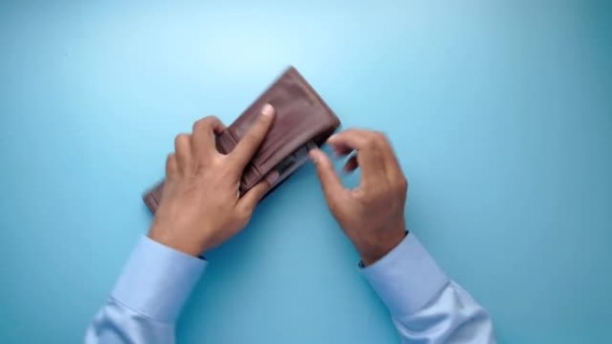 男人的手从钱包里取现金的俯视图